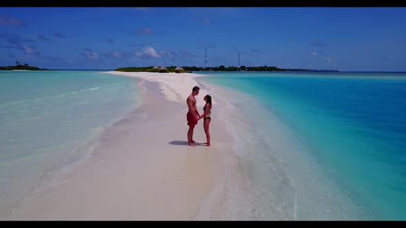 Teenage lovers sunbathing on idyllic bay beach journey by aqua blue sea and white sand background of