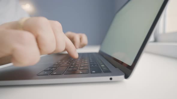 Man inexpertly types with his fingers on laptop