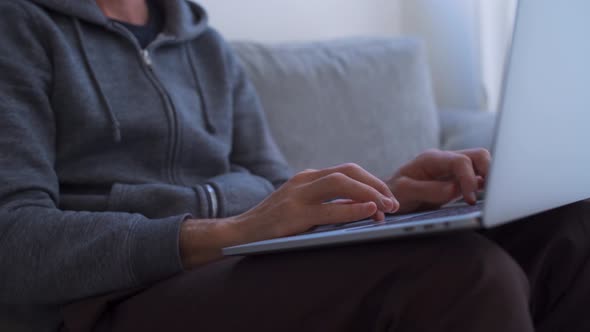 Close up of hands typing on computer while working from home