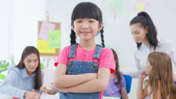 Portrait of Asian kid girl student stand with happiness in class room.