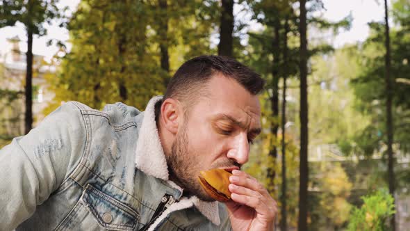 A Modern Young Man Enjoying a Delicious Hamburger