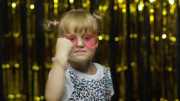 Funny Child Trying To Fight at Camera, Boxing with Expression. Girl Posing on Shiny Background