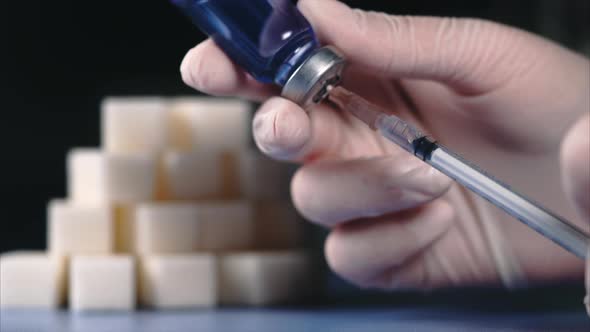 Concept of Diabetes. Sugar Cubes and Syringe in Ampoule of Insulin