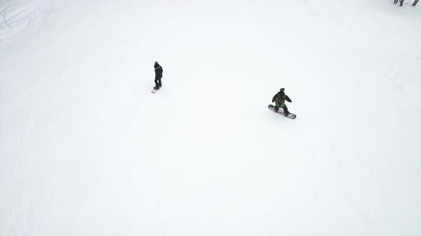 On mountain at Spindleruv Mlyn in Czech Republic two snowboarders preparing going down the hill.