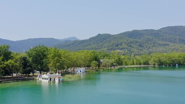 Wide aerial view over lake banyoles boat houses and the mountains on the horizon. Catalonia travel s