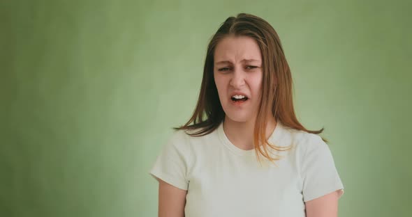 Stylish Woman Grimaces Demonstrating Disgusts on Green