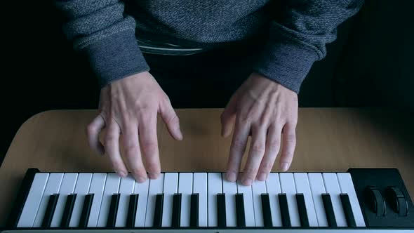 Musician playing on musical keyboard.