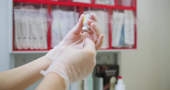 Close Up of Nurse Hands Holding a Coronavirus Measles or Flu Vaccine Applying Vaccine Into the