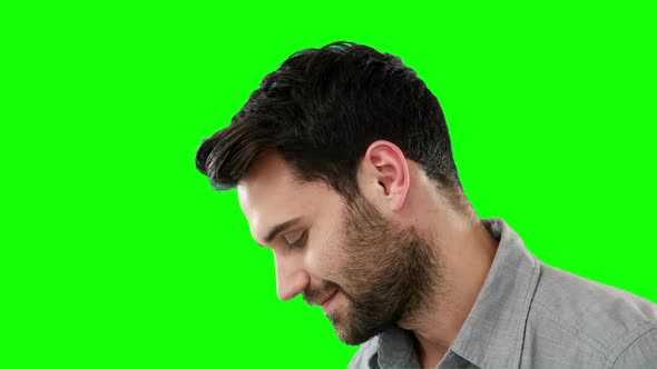 Thoughtful man standing against green background