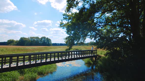 Girl walking over a little bridge in the area of Assen, Netherlands.