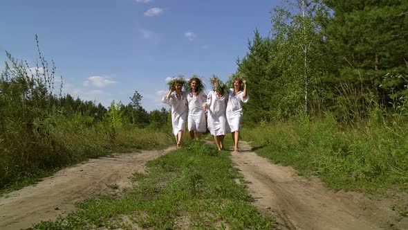 Women in Ethnic Outfits Walking in Countryside