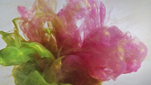 Colorful nacreous paint in water against white background. alt