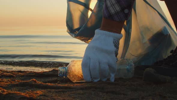 Man Volunteer Collects Plastic on the Beach Closeup