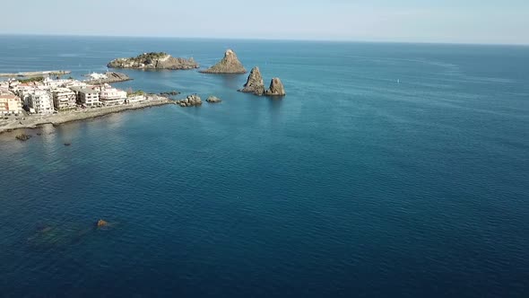 Drone flight along the coastline near the cyclopean islands, Sicily, Italy.