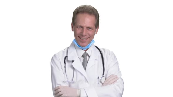 Half-turned Cheerful Mature Doctor with Arms Crossed.