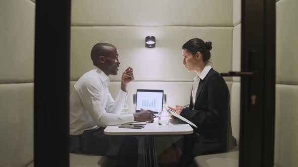 Female Manager and African Businessman Discuss Financial Work Matters While Sitting in the Meeting