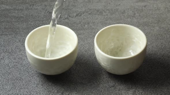 Pouring traditional Japanese sake in cups