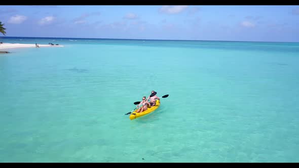 Two people posing on idyllic lagoon beach trip by blue ocean with white sandy background of the Mald