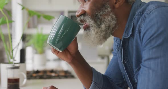 Video of african happy american senior man drinking coffee