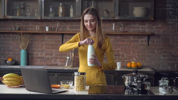 Woman Preparing Breakfast Using Computer in Apartment