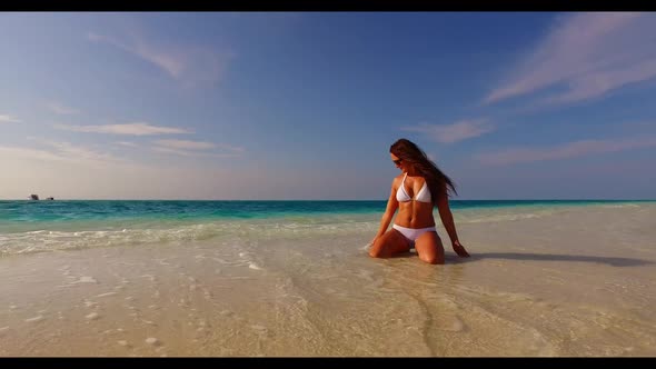 Woman posing on paradise bay beach lifestyle by blue ocean with white sand background of the Maldive
