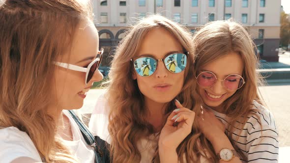 Three young female hipster friends posing outdoors