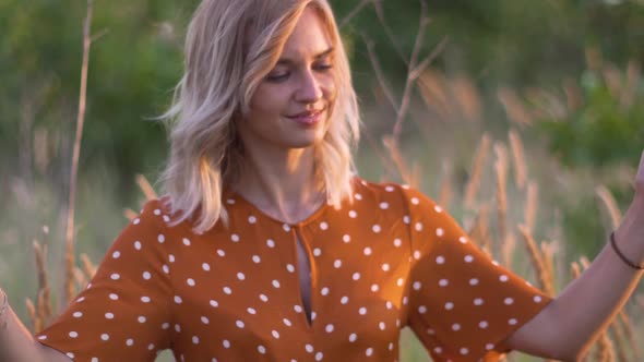 Attractive Young Woman Hands with Golden Glitters in the Field on Sunset