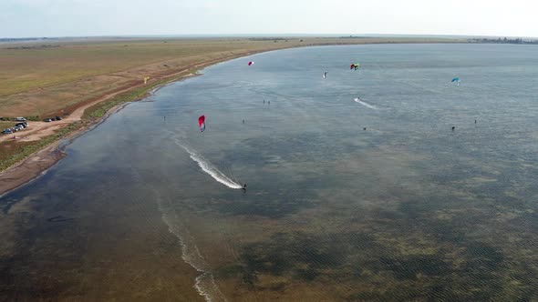 People go kitesurfing on the sea. The wind carries the athlete along the sea waves.