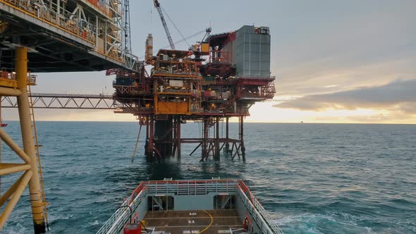 Platform Supply Vessel PSV Near Oil Rig and Drilling Platform