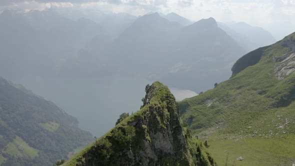 Young man hikes at Klingenstock with a beautiful view over Vierwaldstätterlake, Lucerne, Switzerland