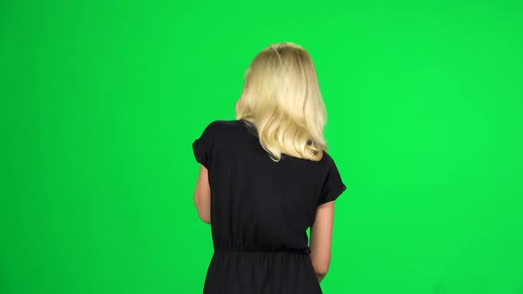 Blonde Woman Goes and Speaks on the Phone. Chroma Key. Back View