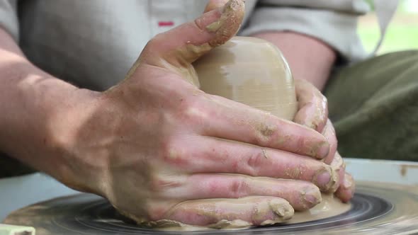 a Male Potter of Caucasian Ethnicity in a Work Shirt Makes a Bowl of Clay