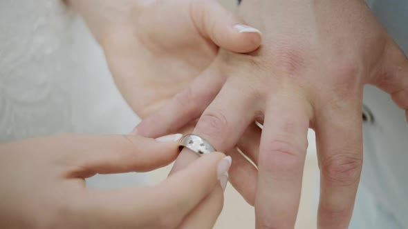 Groom and bride put the wedding rings on the finger. Newly married couple together holding hands