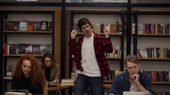 Joyful Excited Handsome European Man in Checkered Shirt Performing Expressive Dance While Listening