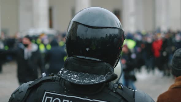 Enforcer in Riot Police Uniform Speaks with Megaphone Bullhorn to Protesters