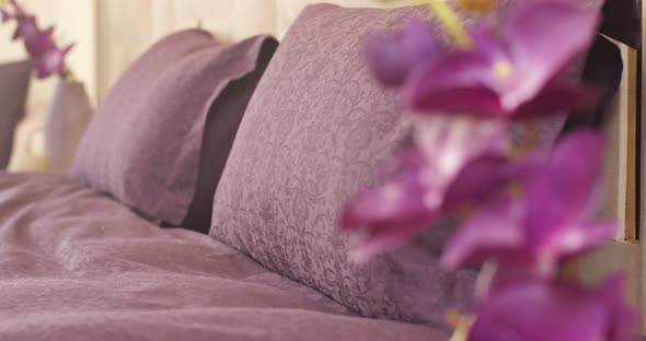 Closeup of Purple Pillows with Floral Patterns and Purple Cover on the Bed