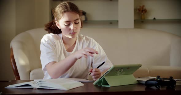 Girl Using Digital Tablet Technology Device in an Online Lesson Talking on Video Via Tablet