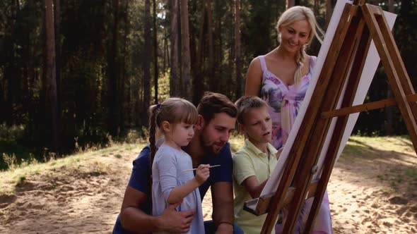 Happy Family Young Parents Drawing Coloring Picture with Brush Helping Cute Child Daughter Enjoying