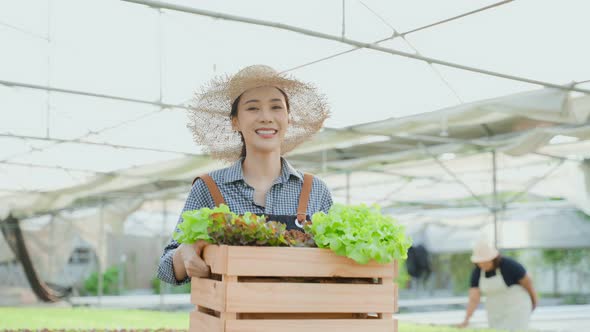 Portrait of Asian young woman farmer hold basket of vegetables in farm.