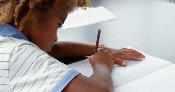 Side view of American african drawing a sketch on notebook in the classroom 4k