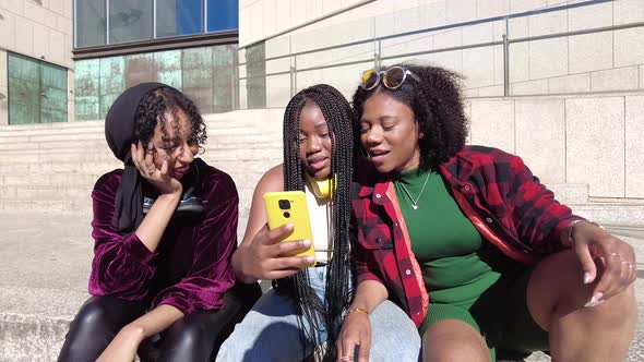 Happy black women taking selfie on street