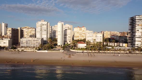 Sideways aerial view of a coastal town in the mediterranean. Playa de San Juan, Alicante.