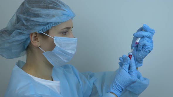 Nurse is filling syringe with drugs for injection. Blood sample. Covid 19 vaccination. Virus concept