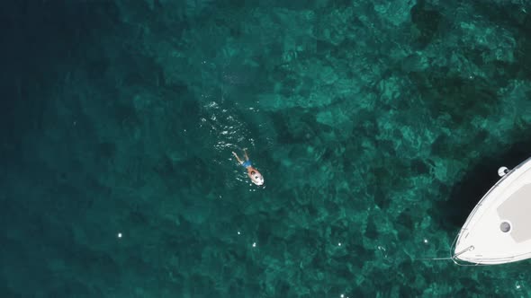 An aerial drone shot of someone using a seascooter. Enjoying the freedom of the ocean, next to a boa
