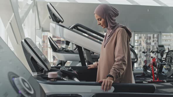 Woman in Hijab Running on Treadmill in Gym