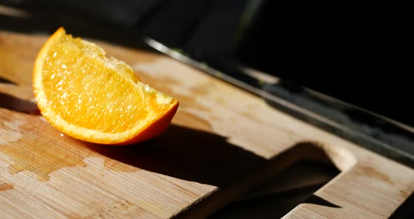 A colorful orange fruit slice on a cutting board in the sunlight for a healthy snack.