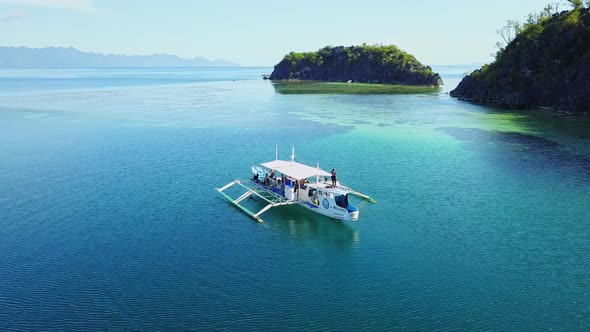 Tourists On Boat Floating On Deep Blue Sea Near Island In El Nido Palawan Philippines