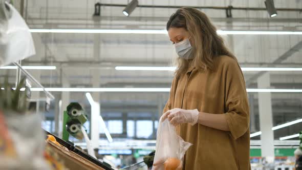 Woman in a Medical Mask and Gloves Selects Oranges in a Grocery Supermarket. Protection From the