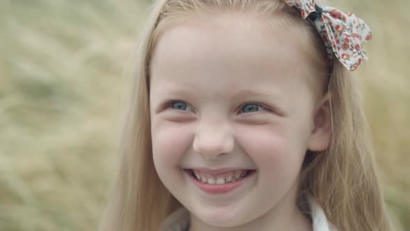 Headshot Portrait of Charming Pretty Little Girl Laughing Looking at Camera and Looking Around