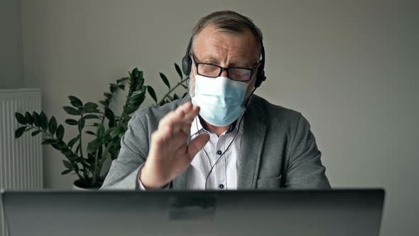 Office Work During the Coronavirus Epidemic. Elderly Businessman Using Laptop and Have Video Call